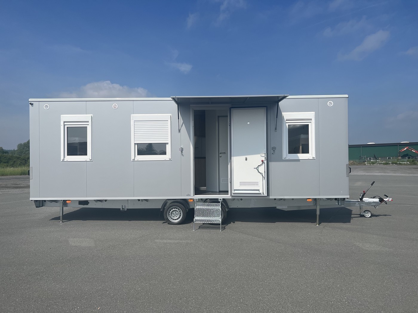 Mannschaftswagen mit Fenstern und Eingangstür – mobiler Aufenthaltsraum für Baustellen, ideal für flexible Einsätze und Transport.